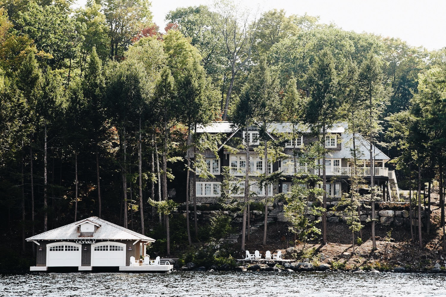 Muskoka Living Projects - Lilyvale Lakehouse designed and built by Muskoka Living. Exterior shot of lakehouse and boathouse from the lake.